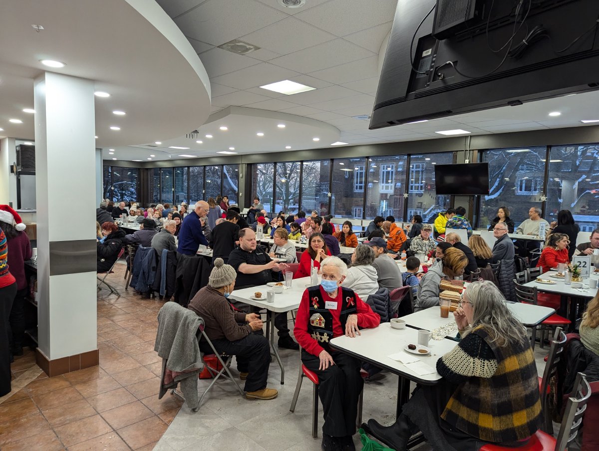 Guests and volunteers sharing the community dinner in 2024.